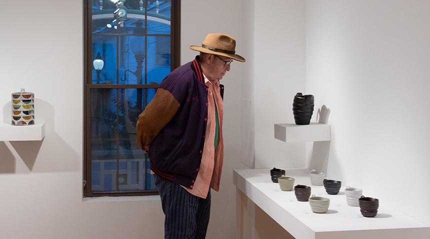 Man looking at pottery cups on display